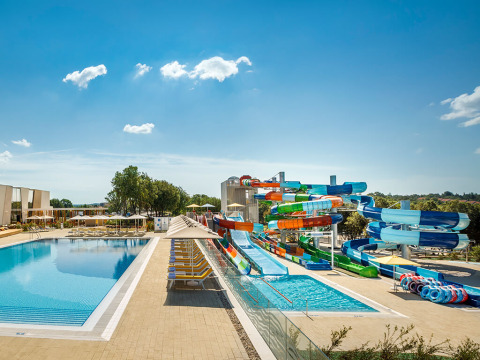 Schwimmbad und bunte Wasserrutschen unter blauem Himmel im Valamar Camping Istra, Istrien, Kroatien.