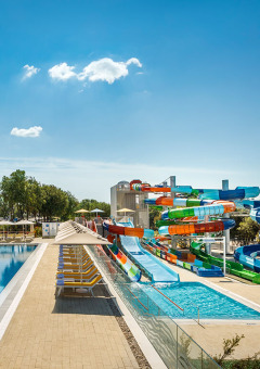 Piscina y toboganes de agua coloridos bajo un cielo despejado en Valamar Camping Istra, Istria, Croacia.