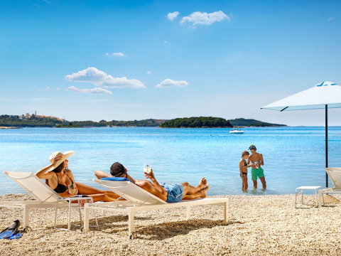 Urlaub im Valamar Camping Istra in Istrien, Kroatien, Familien entspannen am Strand auf Liegestühlen.