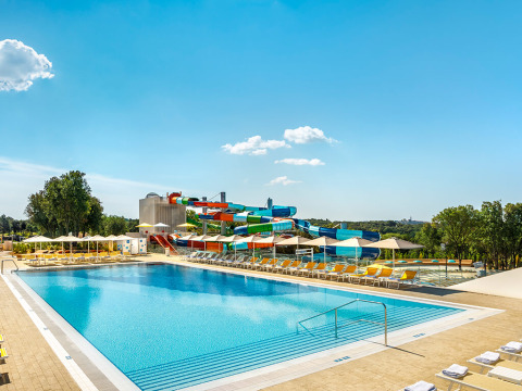 Piscine extérieure et toboggans colorés au Valamar Camping Istra, parc de vacances en Istrie, Croatie, sous ciel bleu.