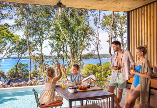Famiglia che si gode la piscina con vista mare a Valamar Camping Istra, parco vacanze in Istria, Croazia.