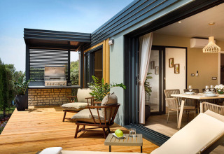 Moderne ferieterrasse med udendørs siddepladser, grillområde og adgang til spisestue i Istrien, Kroatien.