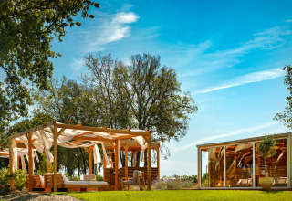 Zona lounge exterior con pérgola de madera y cabaña moderna en Valamar Camping Istra, Istria, Croacia.