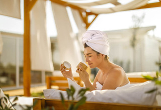 Kvinde slapper af på udendørs spa med håndklæde om håret på Valamar Camping Istra i Istrien, Kroatien.