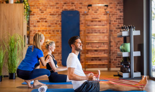 Mensen doen fysiotherapie-oefeningen met elastische banden in de fitness van Valamar Camping Istra, Kroatië.