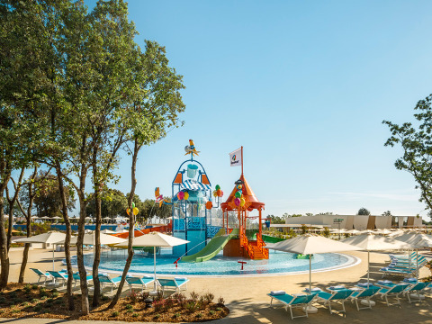 Bunte Wasserspielplatz mit Rutschen und Liegestühlen im Valamar Camping Istra Ferienpark in Istrien, Kroatien.