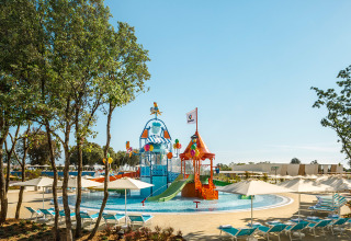 Kleurrijke waterspeelplaats met glijbanen en ligstoelen bij Valamar Camping Istra vakantiepark in Istrië, Kroatië.