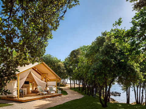 Glamping tent aan zee tussen bomen bij Valamar Camping Istra, een vakantiepark in Istrië, Kroatië.