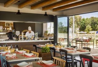 Innenrestaurant im Valamar Camping Istra, Istrien, Kroatien, mit offenen Küche und gedeckten Tischen.