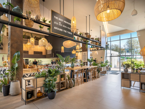 Lyst, moderne restaurantinteriør med grønne planter og store vinduer i Valamar Camping Istra, Kroatien.