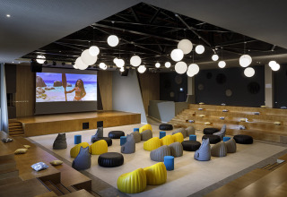 Sala de cine moderna con pufs y pantalla grande en Valamar Camping Istra, parque vacacional en Istria, Croacia.