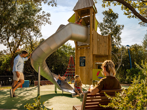 Famille s'amusant sur une aire de jeux avec toboggan au Valamar Camping Istra, parc de vacances en Istrie, Croatie.