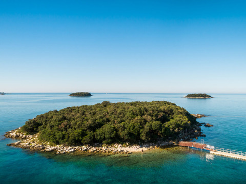 A scenic island surrounded by clear blue water at Valamar Camping Istra holiday park in Istria, Croatia.