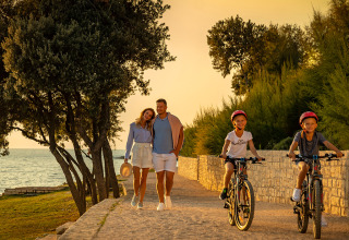 Famille profitant du soir près de la mer à Valamar Camping Istra, Istrie, Croatie, deux enfants à vélo.