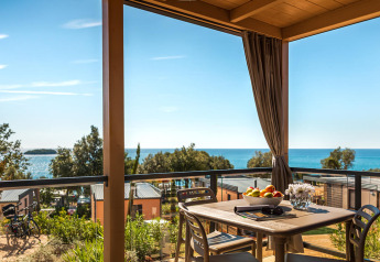 Zicht op zee vanaf Bella Vista Chalet bij Valamar Camping Istra, Kroatië, met terras en eettafel.