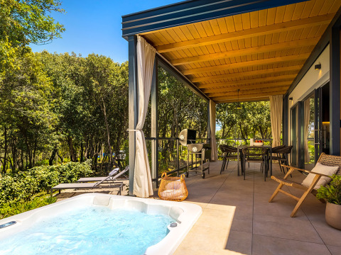 Overdekt terras met jacuzzi en eetruimte aan Sunset Villa bij Valamar Camping Istra in Kroatië.
