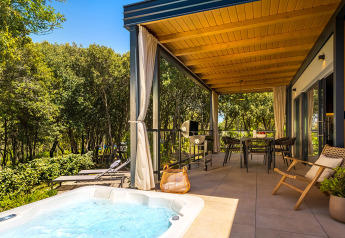 Terrazza coperta con jacuzzi, tavolo da pranzo e natura a Sunset Villa, Valamar Camping Istra, Croazia.