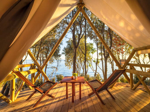 Aussicht von einem Sunset Bell Tent Seaview im Valamar Camping Istra in Kroatien mit Holzterrasse am Meer.