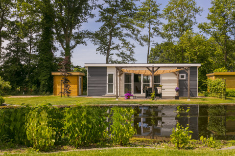 Casa de vacaciones junto a un estanque en Holiday Park De Lochemse Berg, Gelderland, Países Bajos.