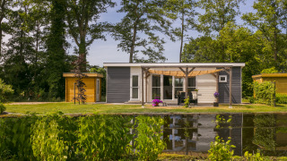 Vakantiehuisje aan het water in Holiday Park De Lochemse Berg, midden in het groen in Gelderland, Nederland.
