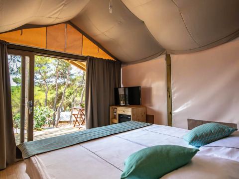 Interieur van een Mini Lodge safari tent bij Camping Arena One 99 Glamping in Kroatië, met dubbel bed.