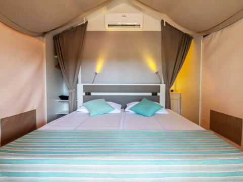 Interno camera da letto nella tenda safari Mini Lodge al Camping Arena One 99 Glamping in Croazia.