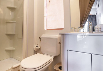 Moderne badeværelse i et safari telt ved Camping Arena One 99 Glamping i Kroatien med bruser og toilet.