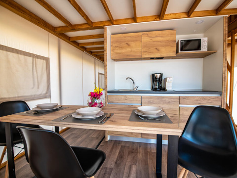 Cuisine moderne et coin repas dans une tente safari loft Premium au Camping Arena One 99 Glamping en Croatie.