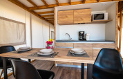 Cucina e zona pranzo moderna in una tenda safari Premium presso Camping Arena One 99 Glamping in Croazia.