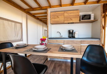 Cucina e zona pranzo moderna in una tenda safari Premium presso Camping Arena One 99 Glamping in Croazia.