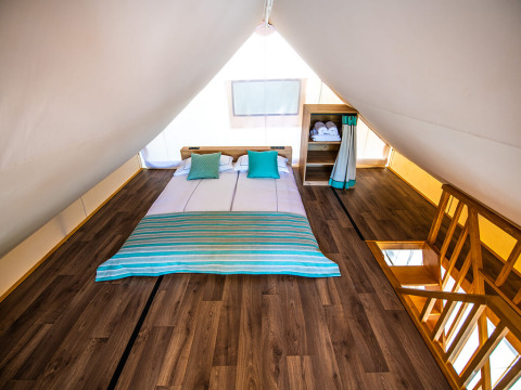Premium safarilofttent met tweepersoonsbed en houten vloer bij Arena One 99 Glamping, Kroatië.