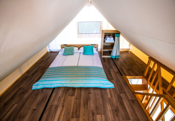 Loft i Premium safari telt med dobbeltseng, trægulv og moderne indretning på Camping Arena One 99 Glamping, Kroatien.