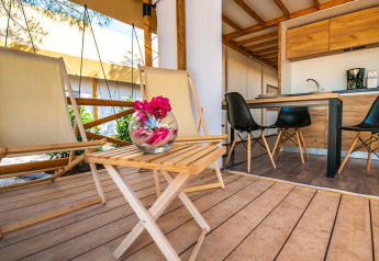 Premium two bedroom safari loft tent with wooden deck, lounge chairs and kitchen at Arena One 99 Glamping, Croatia.