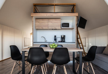 Interior of a premium three bedroom safari tent at Camping Arena One 99 Glamping, featuring kitchen and dining area.