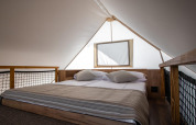 Chambre lumineuse avec lit double dans la tente safari premium trois chambres au Camping Arena One 99 Glamping, Croatie.