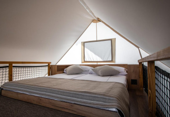 Camera luminosa con letto matrimoniale nella tenda safari premium tre camere al Camping Arena One 99 Glamping, Croazia.