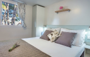 Camera da letto in Ježevac Home al Valamar Camping Ježevac, Croazia, con letto matrimoniale e arredi moderni.