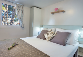 Bedroom inside Ježevac Home at Valamar Camping Ježevac, Croatia, featuring a cozy double bed and modern decor.