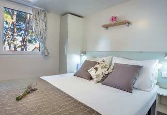 Camera da letto in Ježevac Home al Valamar Camping Ježevac, Croazia, con letto matrimoniale e arredi moderni.