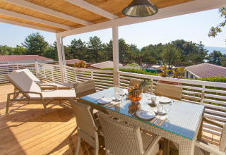 Sunny terrace with dining table and loungers at Ježevac Home, Valamar Camping Ježevac, Croatia.