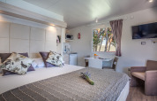 Camera moderna al Lungomare Chalet con vista mare, letto matrimoniale, angolo cottura e zona pranzo.