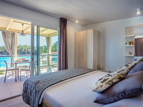 Camera luminosa con letto matrimoniale, balcone e vista spettacolare sul mare al Lungomare Chalet a Ježevac.