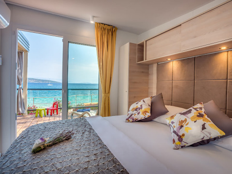 Moderne slaapkamer met uitzicht op zee en terras bij Lungomare Home, Valamar Camping Ježevac, Kroatië.