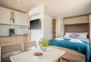 Moderne studio met keuken, eettafel en dubbel bed in Lungomare Chalet, Valamar Camping Ježevac, Kroatië.