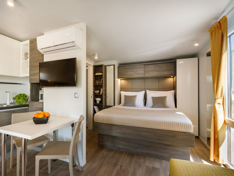 Moderne lodge met dubbel bed, eethoek en zeezicht in Lungomare Chalet op Valamar Camping Ježevac, Kroatië.