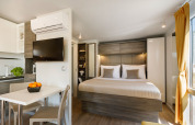 Moderne lodge met dubbel bed, eethoek en zeezicht in Lungomare Chalet op Valamar Camping Ježevac, Kroatië.