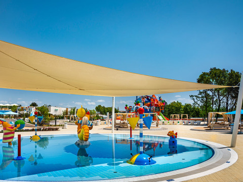 Piscina infantil con juguetes de agua y sombra en Bella Vista Chalet, Valamar Camping Istra, Croacia.
