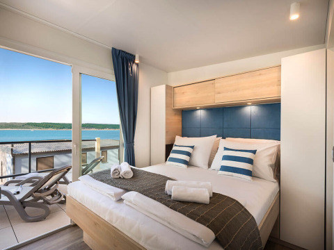 Moderne slaapkamer in Marbello Home, Valamar Camping Istra, Kroatië met balkon en zeezicht.