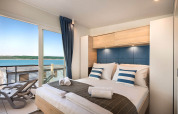 Moderne slaapkamer in Marbello Home, Valamar Camping Istra, Kroatië met balkon en zeezicht.