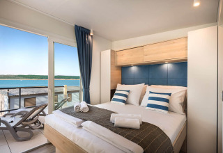 Moderne slaapkamer in Marbello Home, Valamar Camping Istra, Kroatië met balkon en zeezicht.